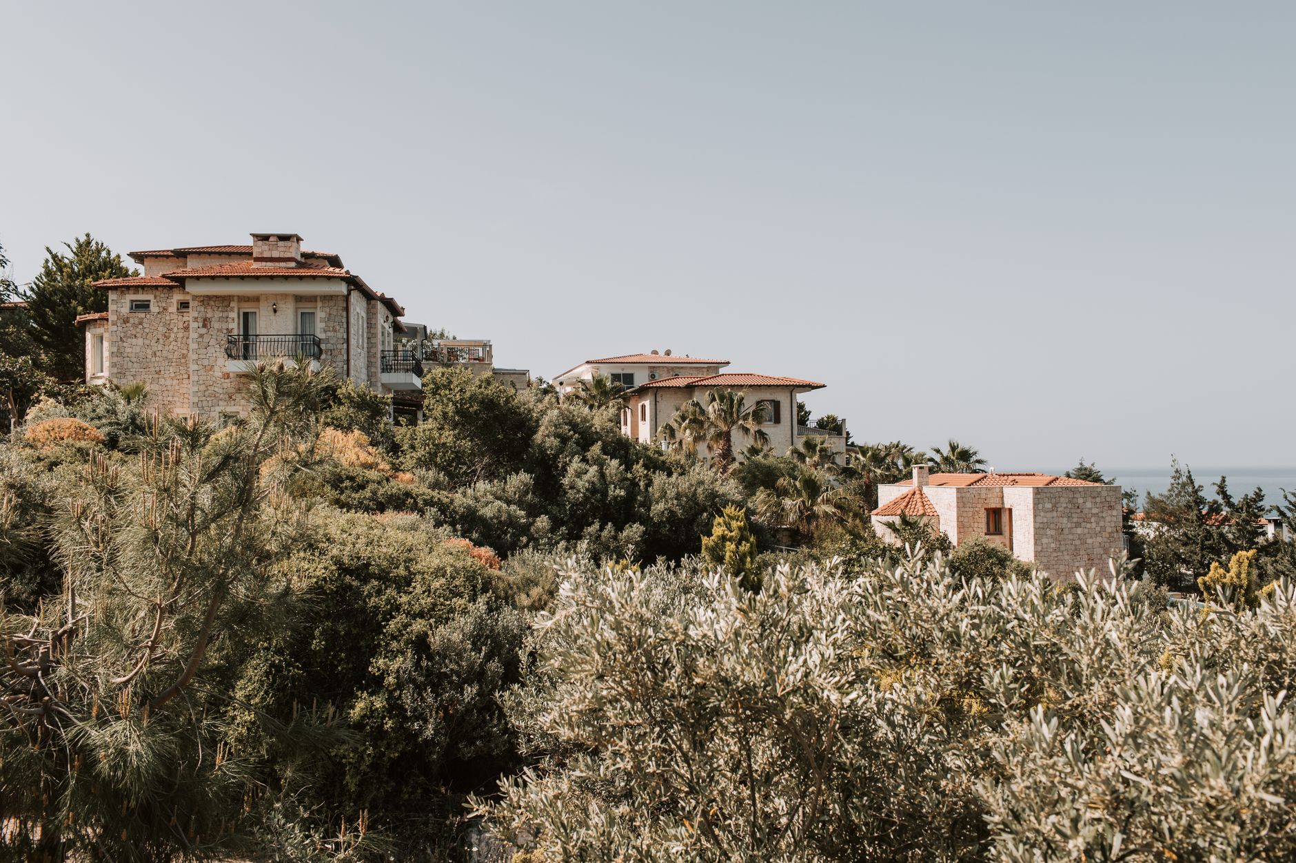 Çeşme'de taş villalar, kiremit çatılar ve denize bakan yeşillik